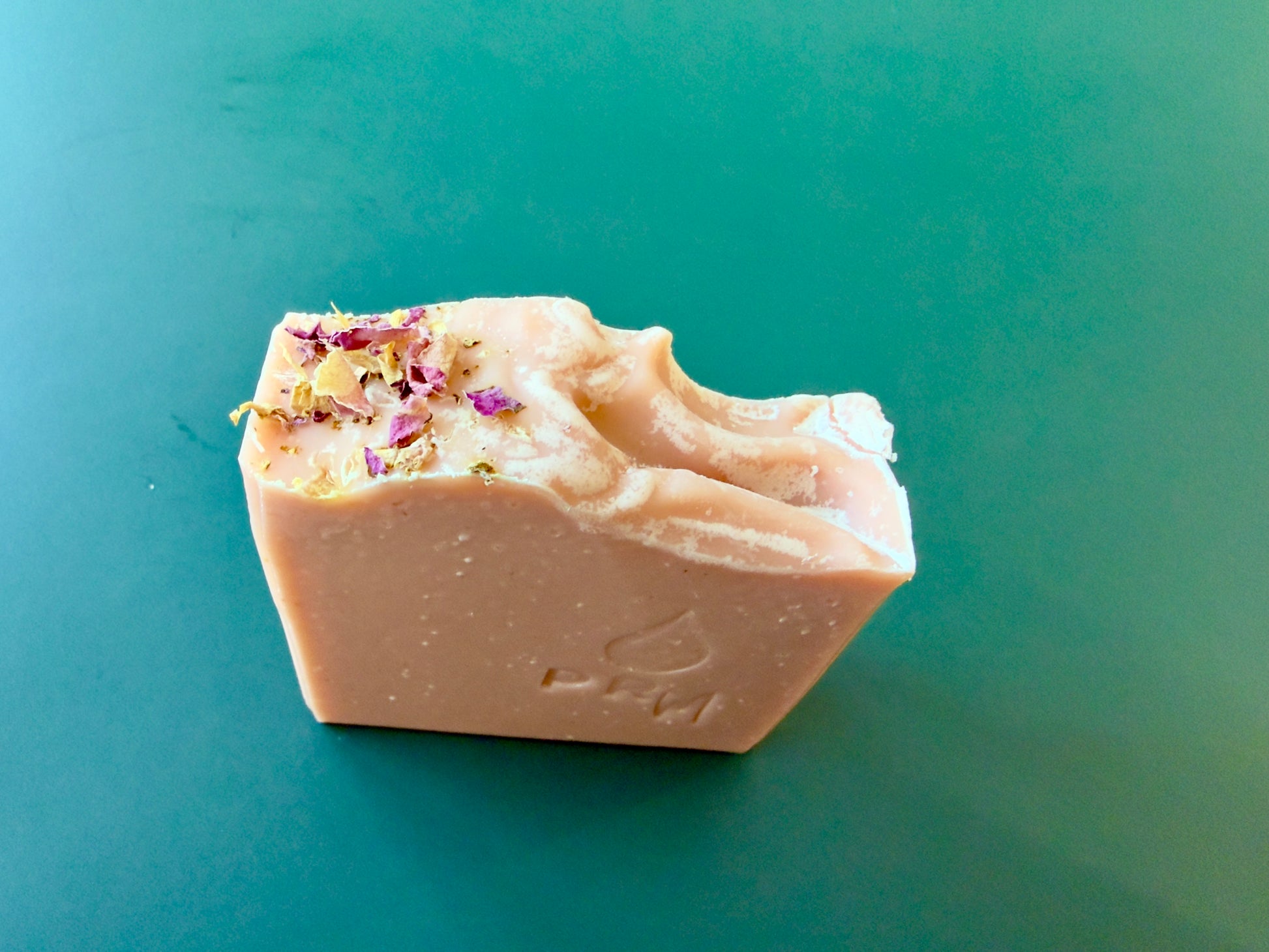 Handcrafted Mandarin Lavender soap bar with PRM stamp and dried rose petal topping.