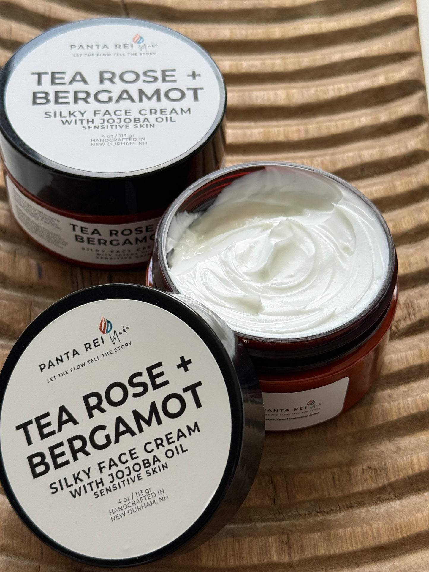 Two jars of Panta Rei Tea Rose + Bergamot silky face cream on a wooden surface.