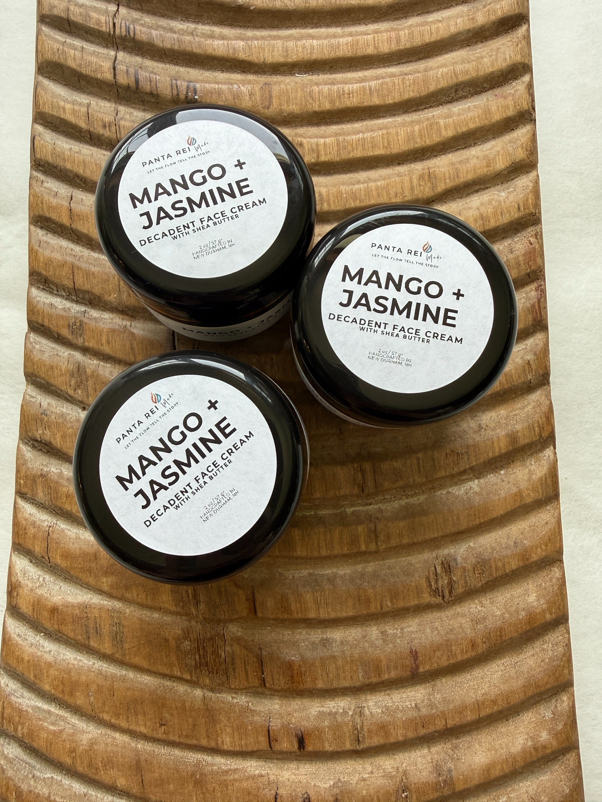 Three jars of Mango + Jasmine Decadent Face Cream on a wooden surface