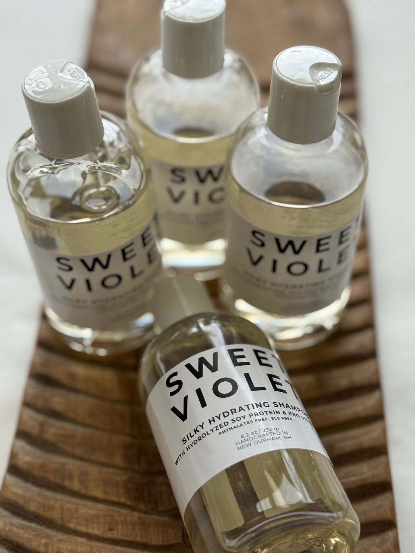 Panta Rei Made Sweet Violet shampoo in clear bottles with white flip-top caps.