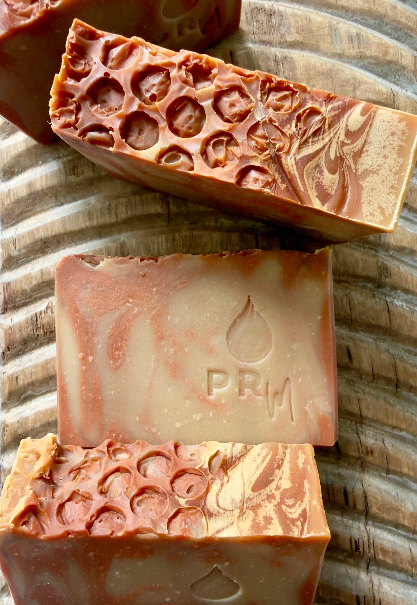 Apricot + Honey small batch soap bar with orange and cream swirl and PRM stamp.