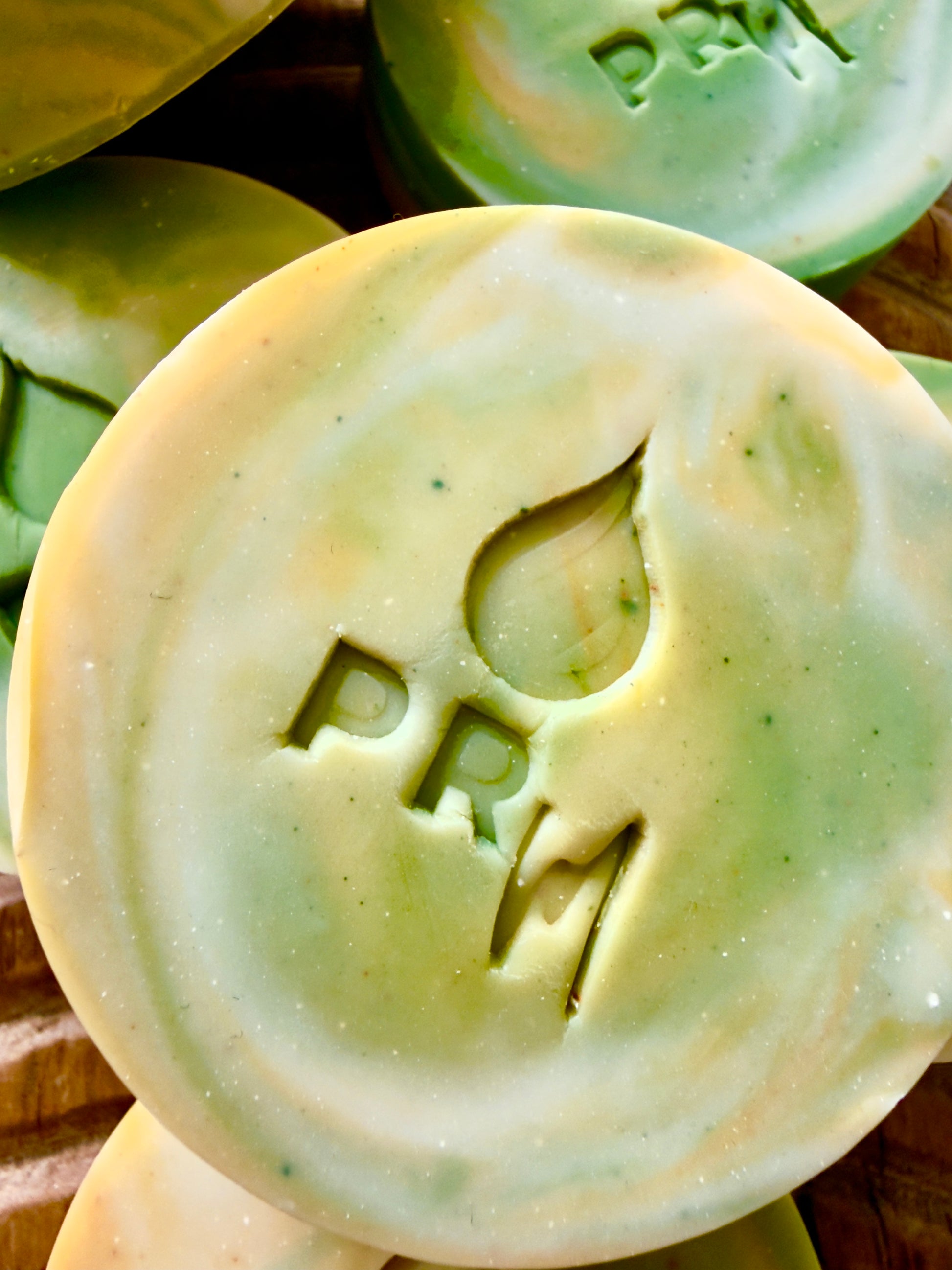 Close-up of Lemon Basil Lavender milk soap with PRM stamped into the bar.